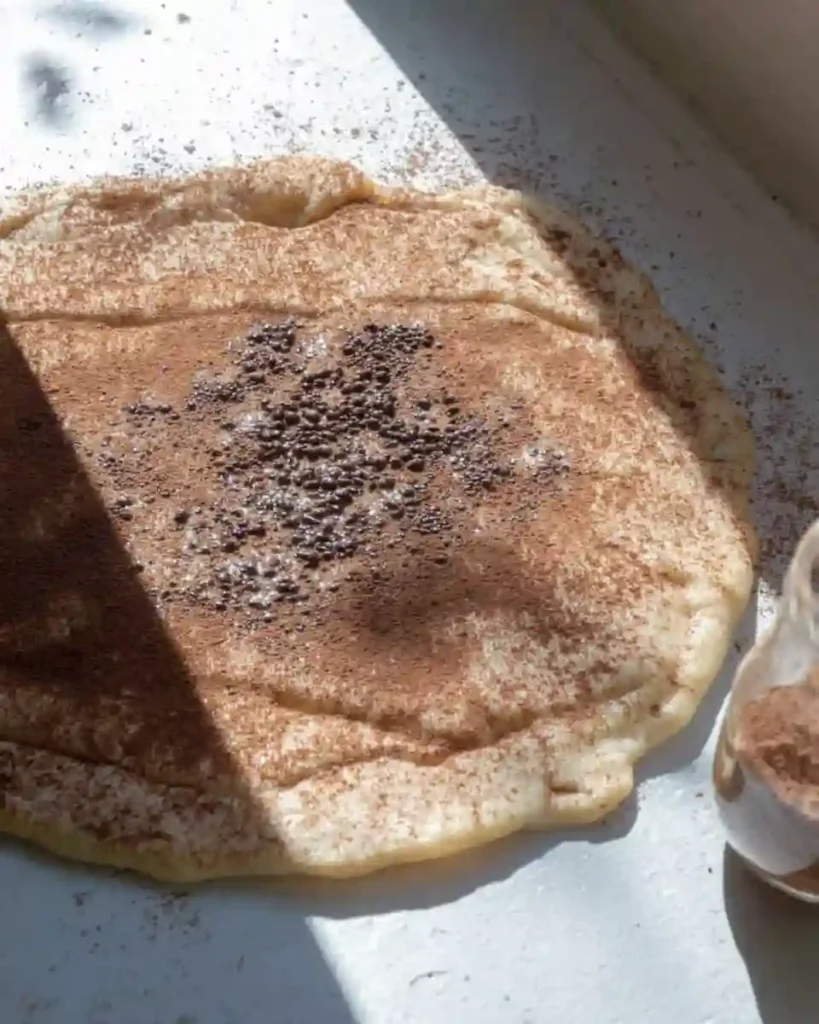 How to Make Cinnamon Roll Scones That Delight Every Bite 11 Dough sheet with cinnamon sugar mixture spread evenly across the surface